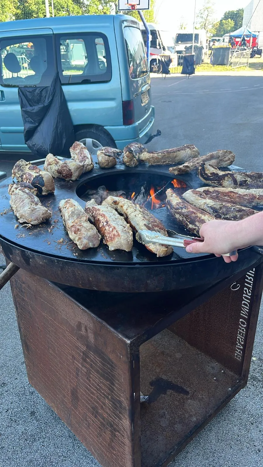 Cuisson de viandes sur brasero mobile en acier lors d'un événement
