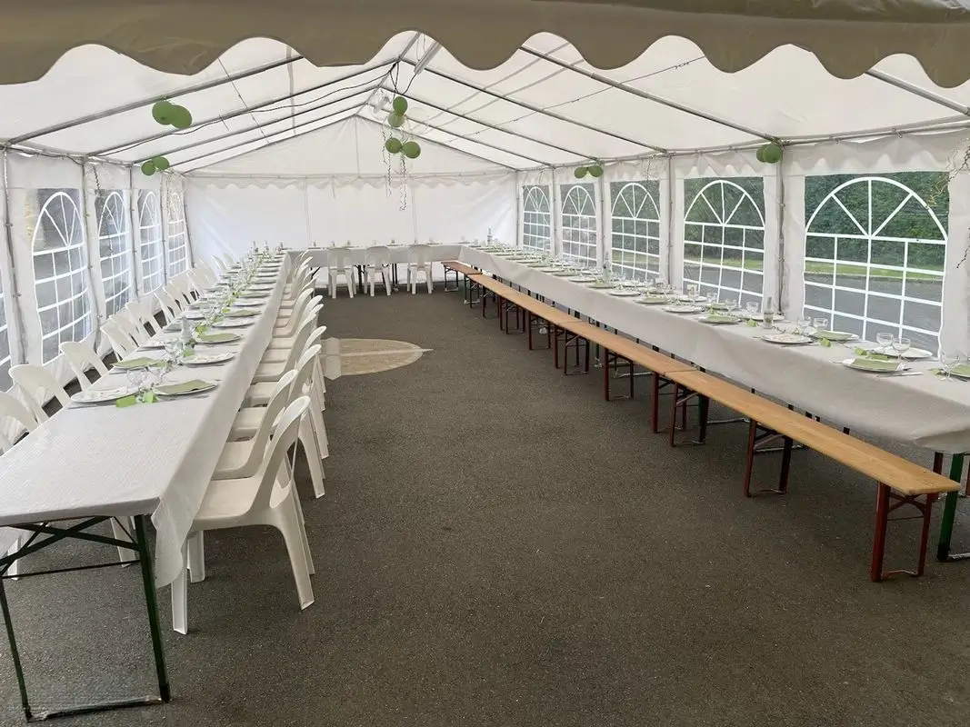 Barnum installé pour accueillir un événement extérieur avec tables et bancs